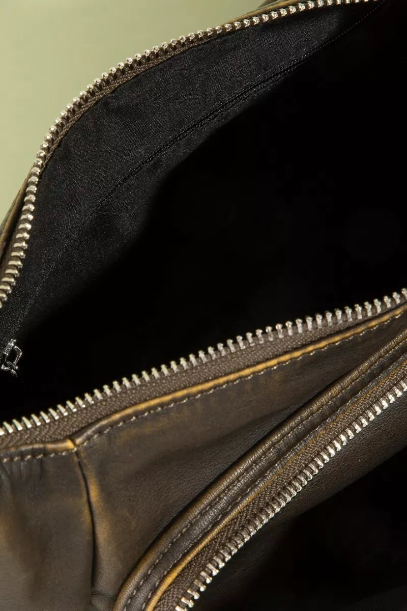 Close-up of a leather bag with a zipper, showing the interior.