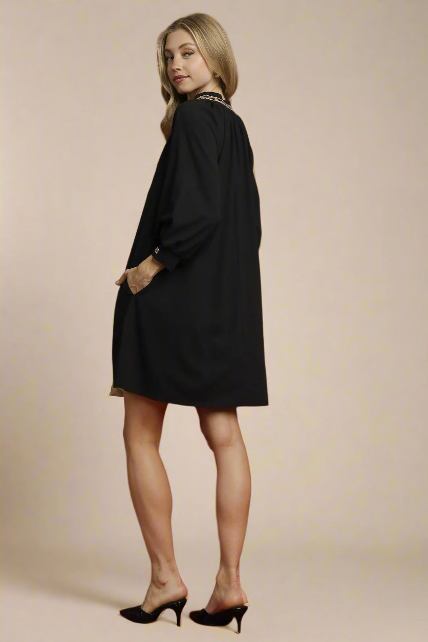 Woman wearing a black dress against a red background