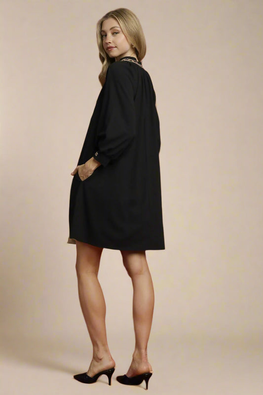 Woman wearing a black dress against a red background