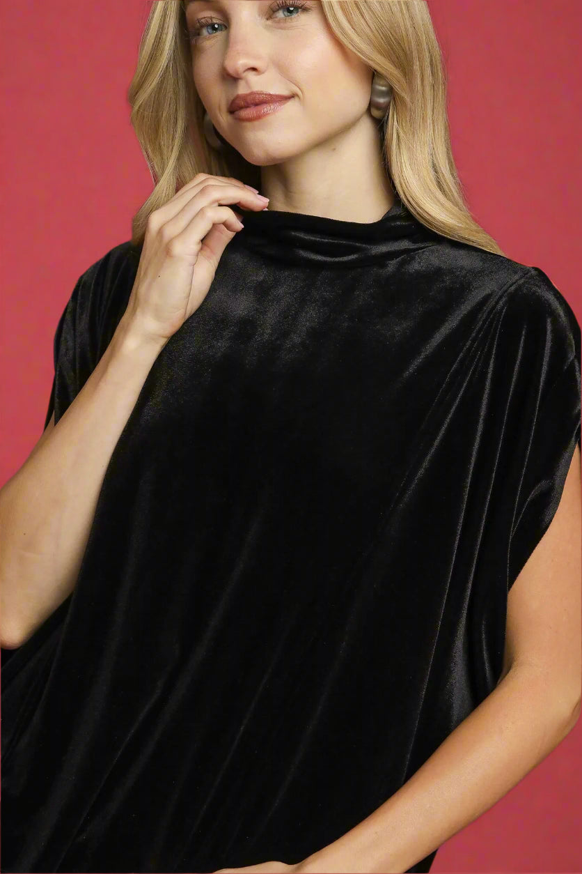 Woman wearing a black velvet dress against a red background