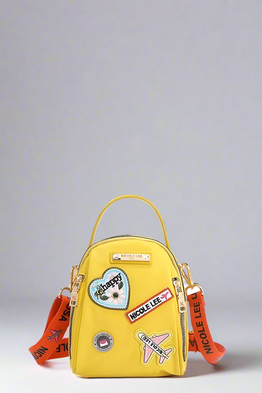 Yellow backpack with colorful patches and straps on a white background
