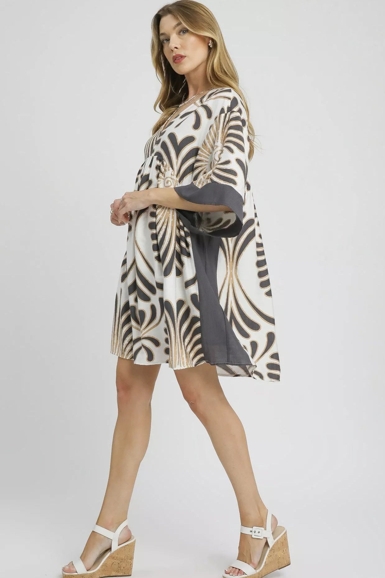 Woman wearing a zebra print dress with a gray belt on a white background