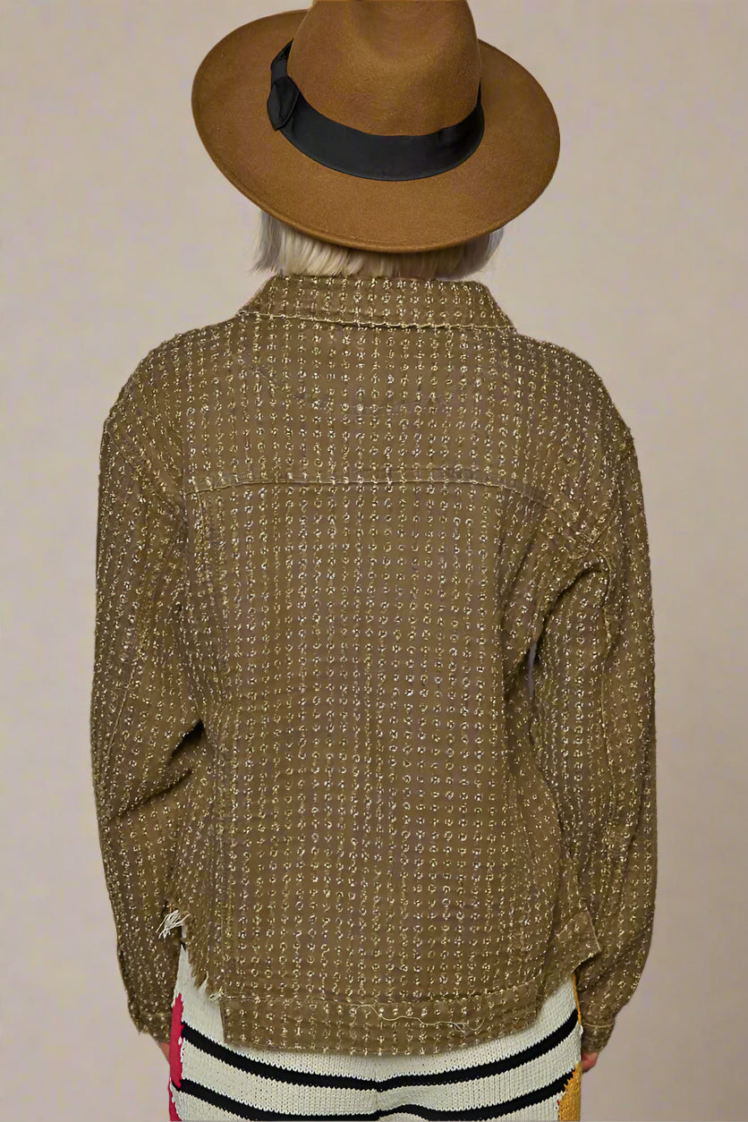 Person wearing a brown textured jacket and hat against a beige background