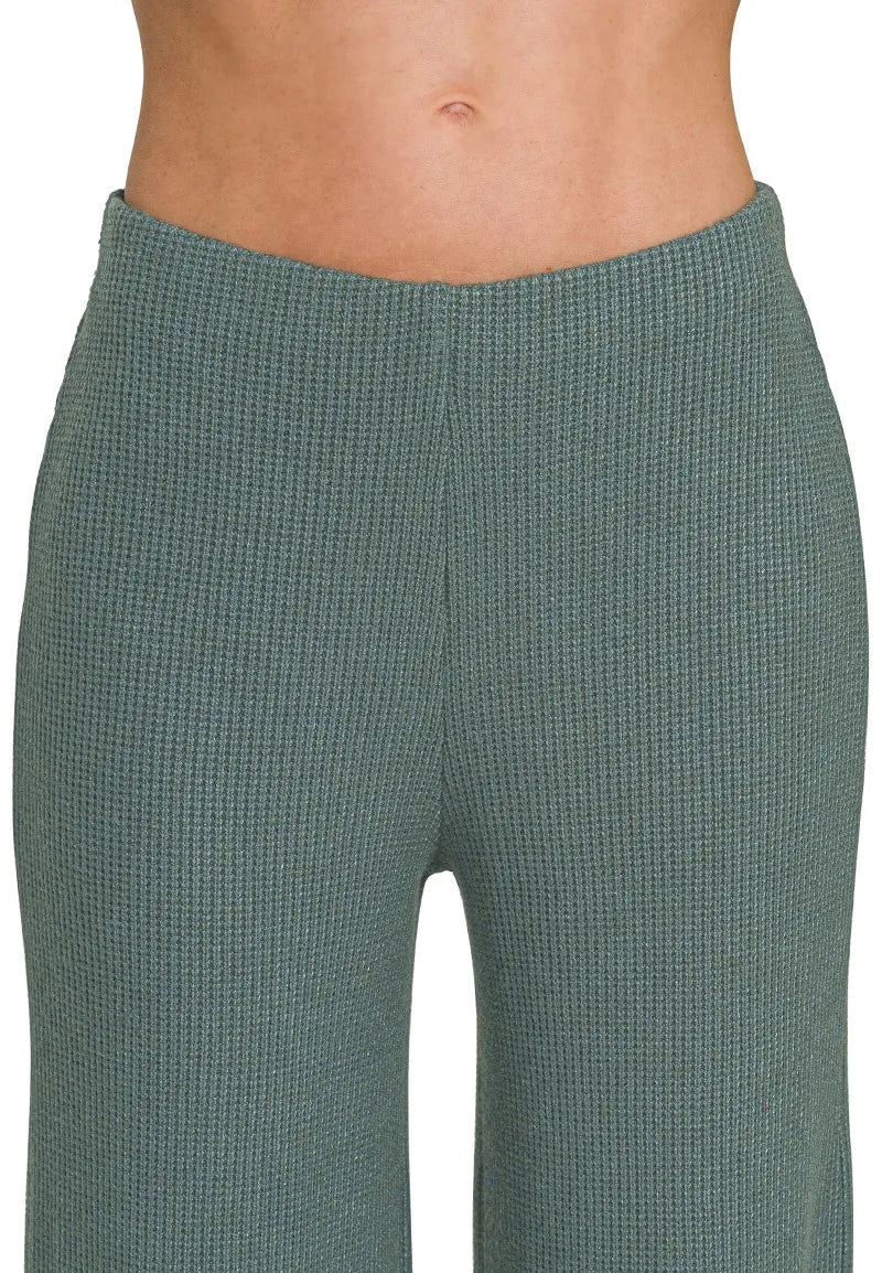 Green textured pants on a white background