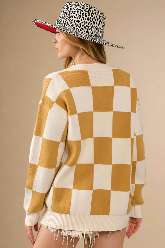 Person wearing a checkered sweater and leopard print hat on a plain background