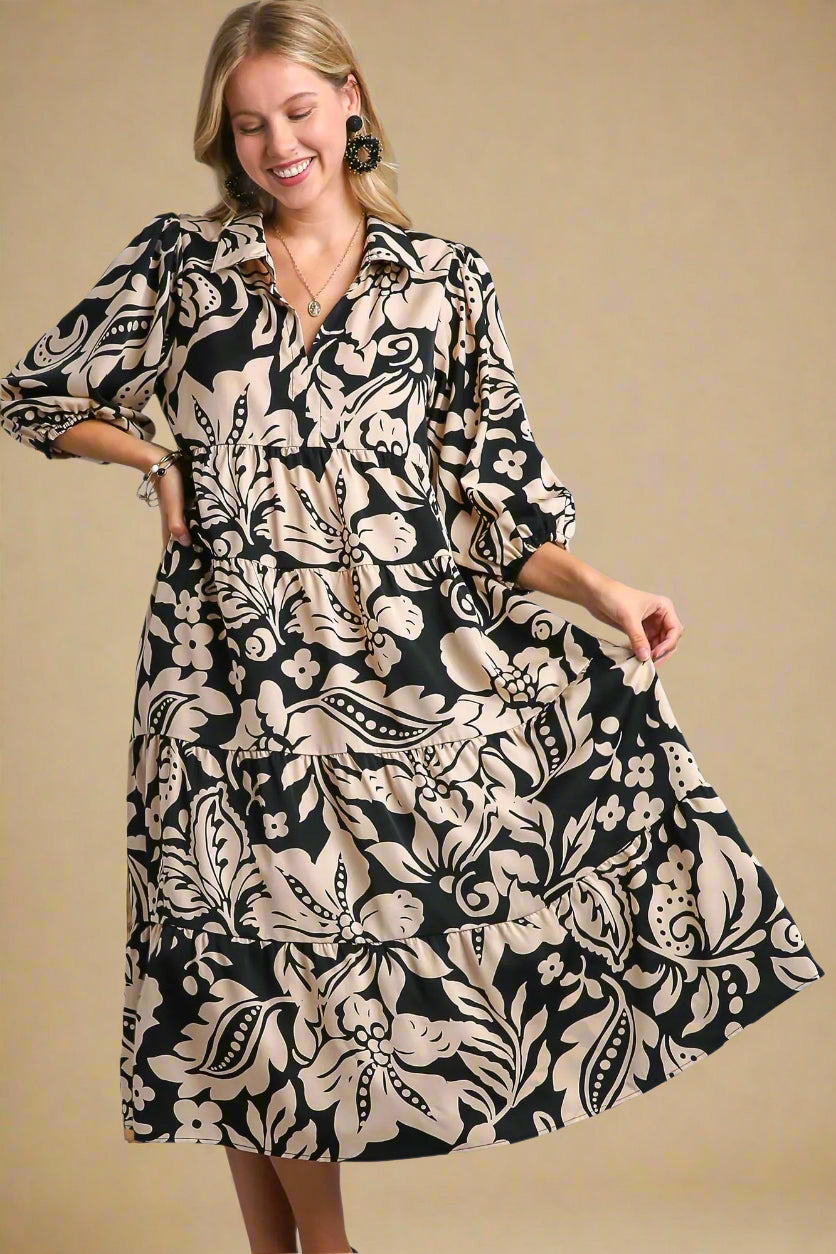 Woman wearing a black and beige patterned dress on a beige background