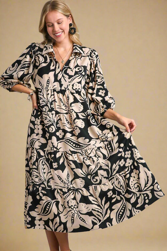 Woman wearing a black and beige patterned dress on a beige background