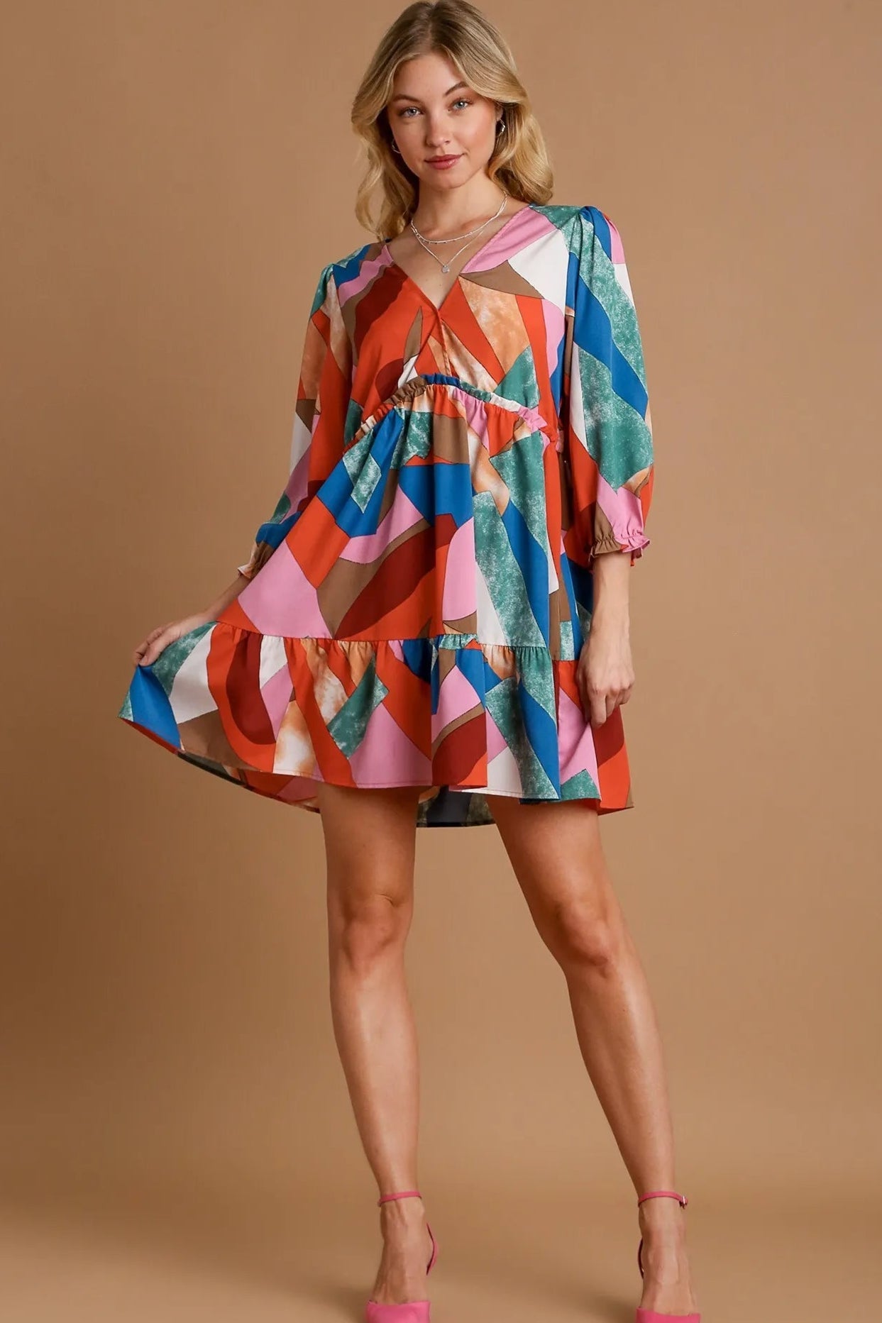 Woman wearing a colorful dress with a wine mix pattern on a beige background