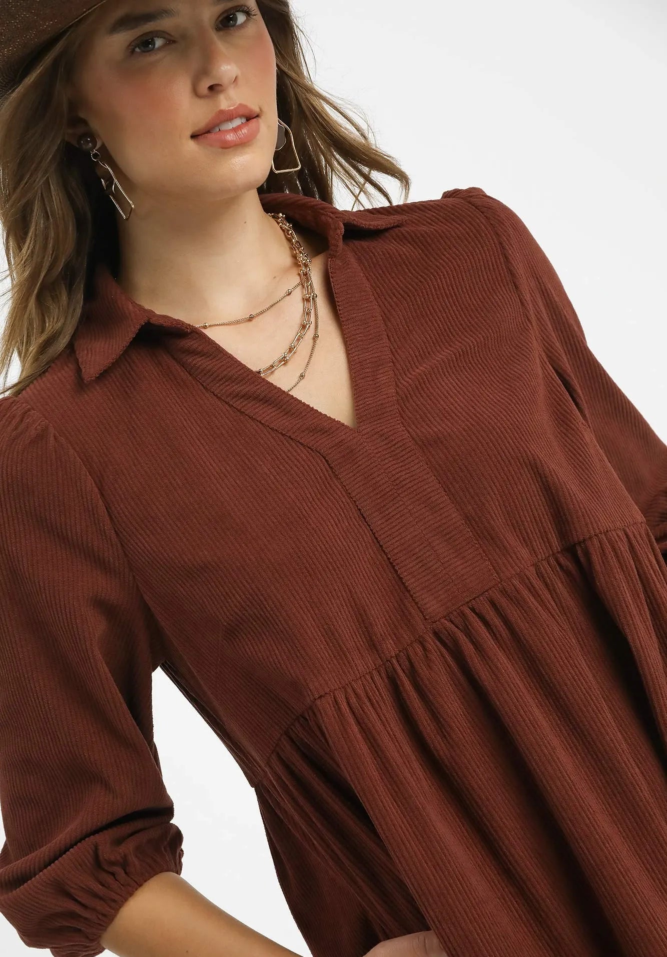 Woman wearing a brown dress with a plain background