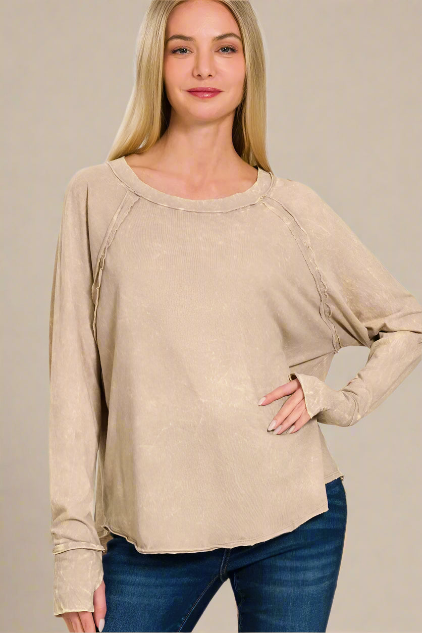 Woman wearing an ash mocha long-sleeve top on a beige background