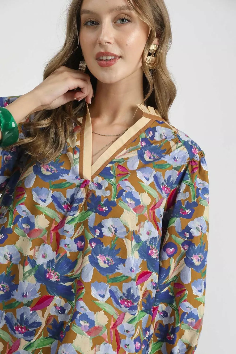 Woman wearing a colorful floral dress with a plain background