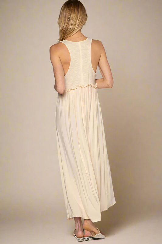 Woman wearing a long beige dress against a plain background