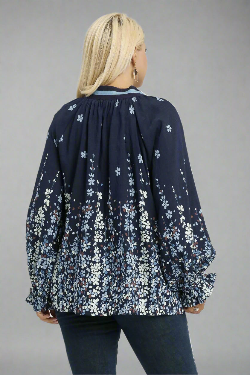 Woman wearing a navy floral blouse on a white background