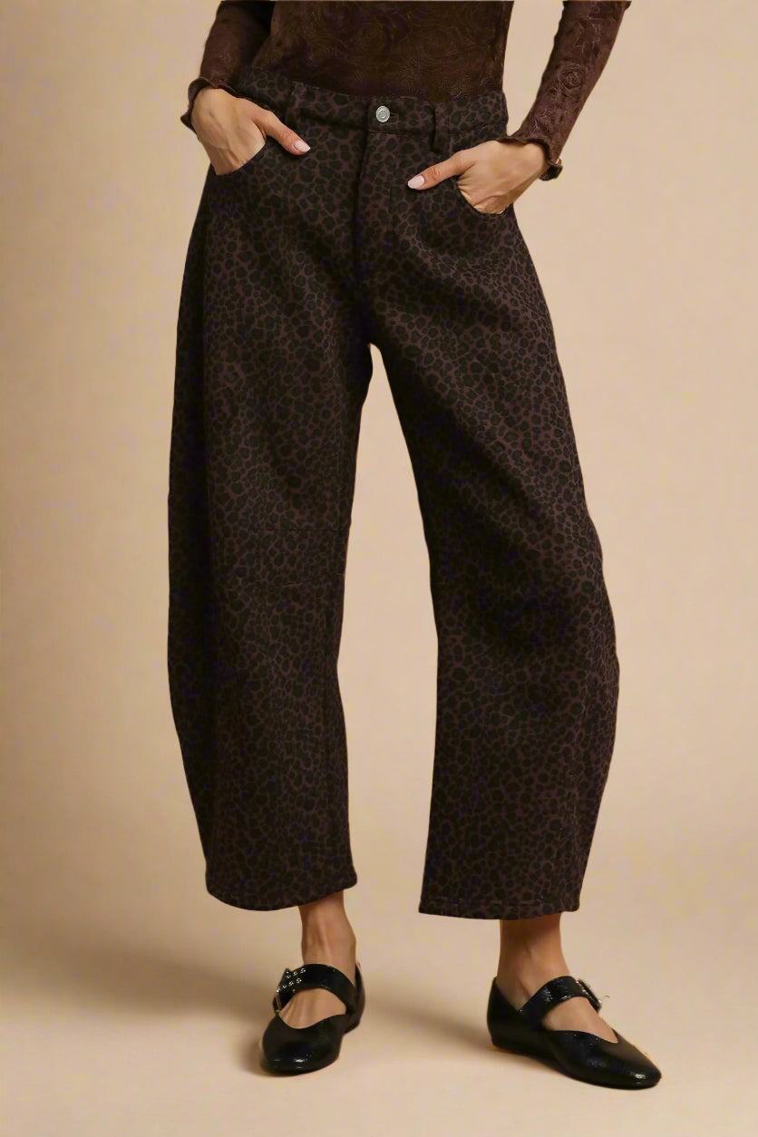 Person wearing brown patterned pants on a beige background