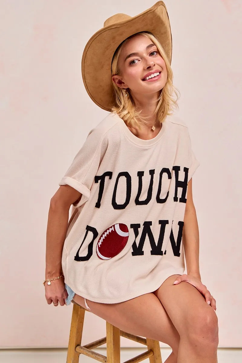 Woman wearing a 'Touchdown' t-shirt and straw hat on a white background