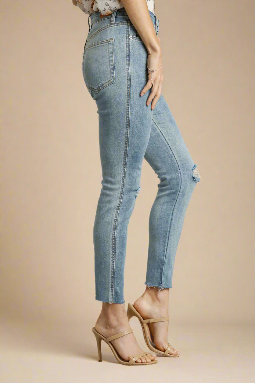 Denim jeans worn by a person on a beige background