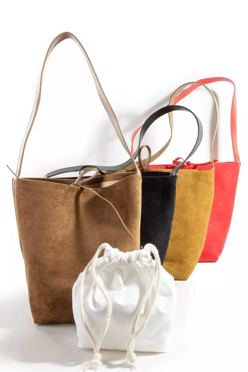 Three handbags in brown, black, and red with a white drawstring bag on a white background.