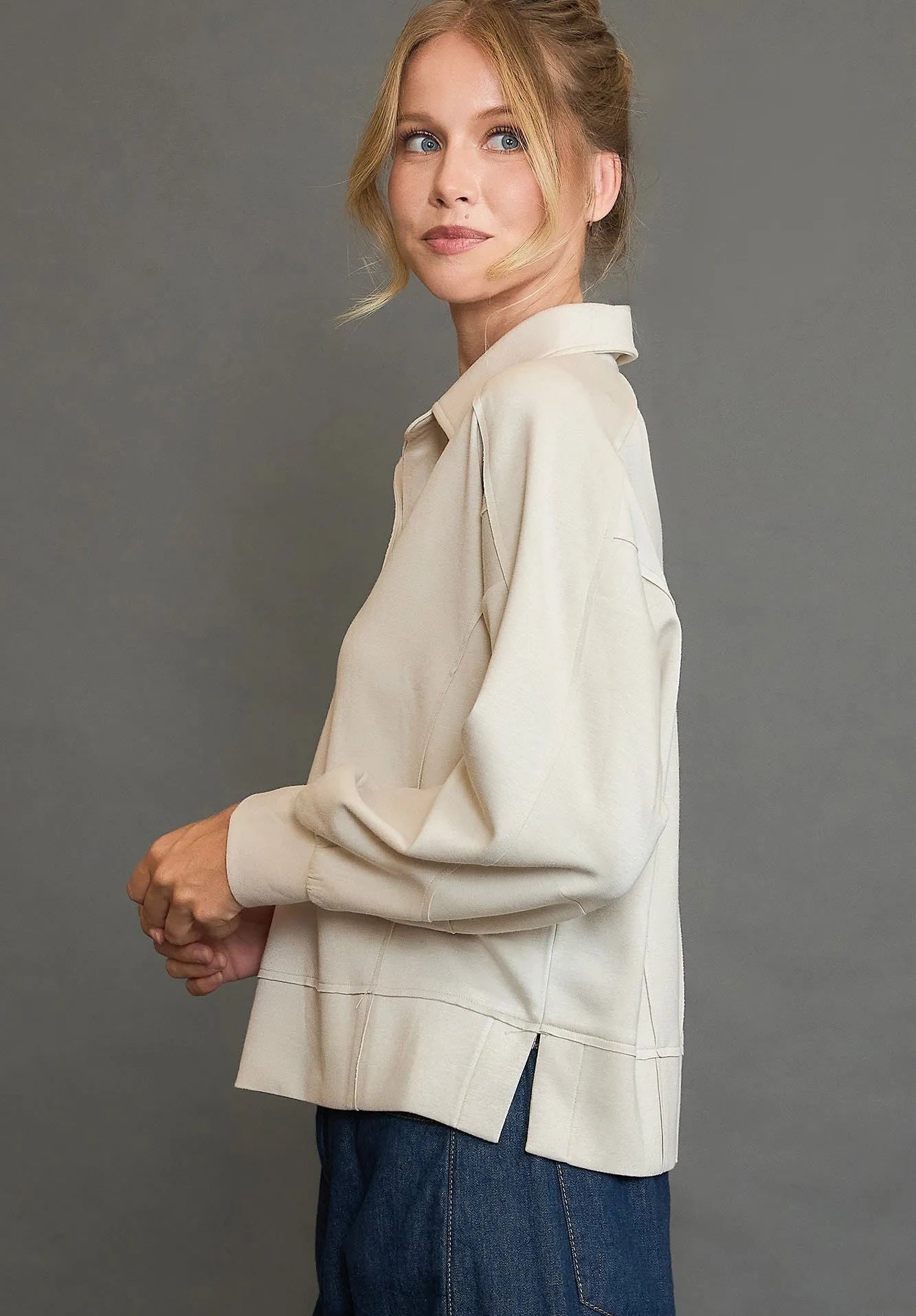 Woman wearing a beige blouse with a gray background