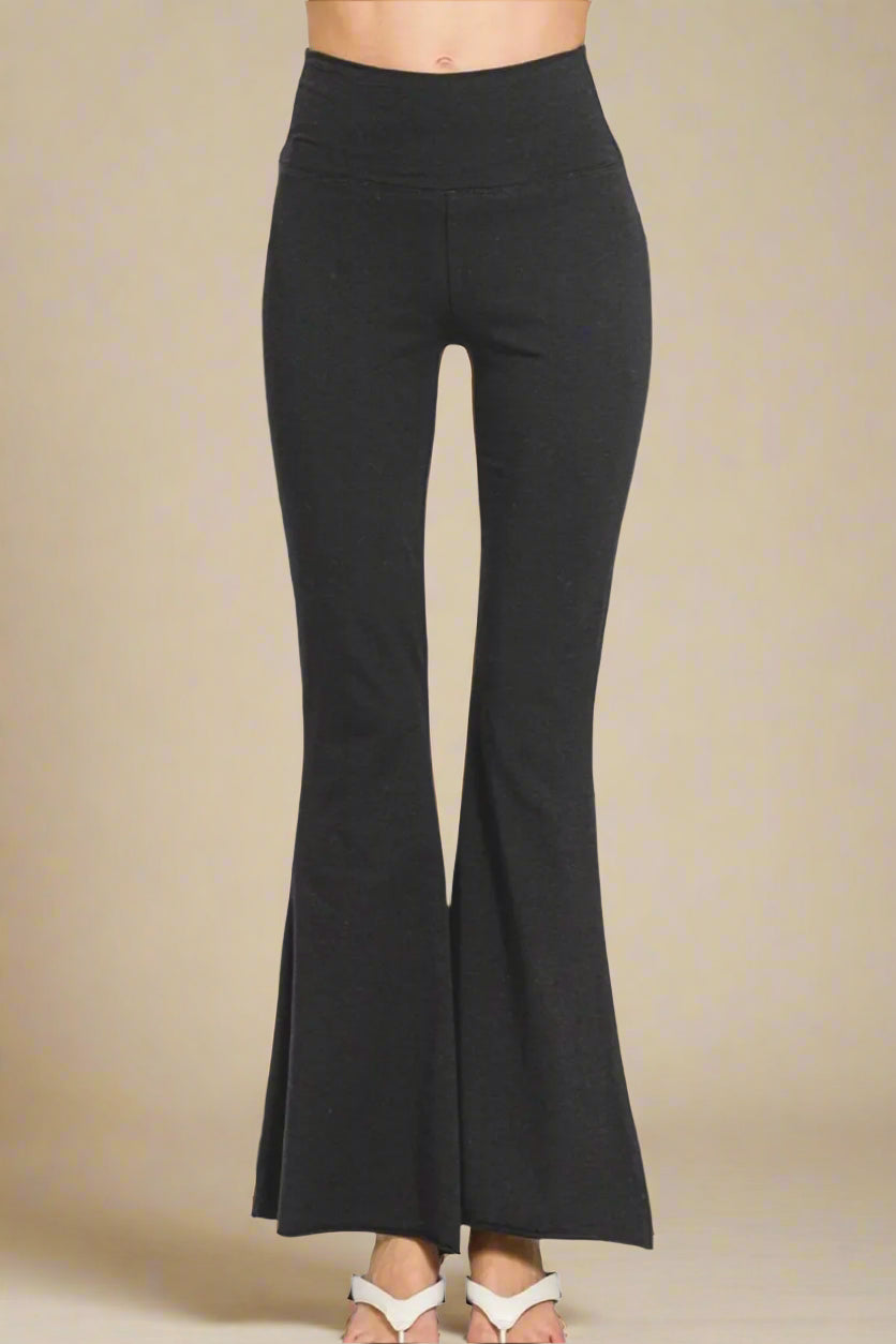 Black flared pants on a beige background