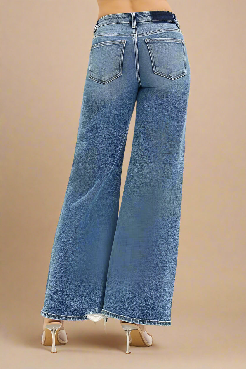 Blue jeans worn by a person on a white background