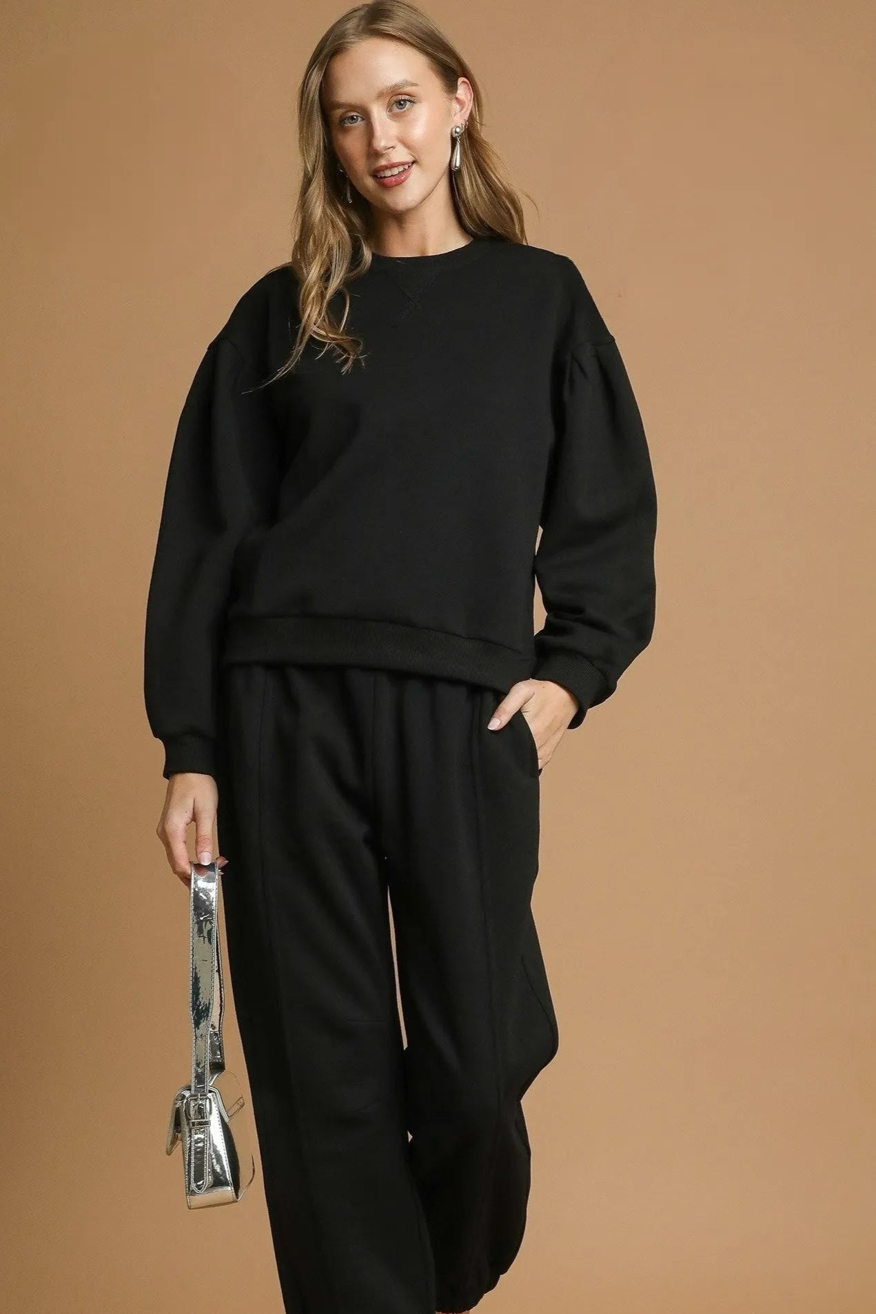 Woman wearing a black outfit against a brown background