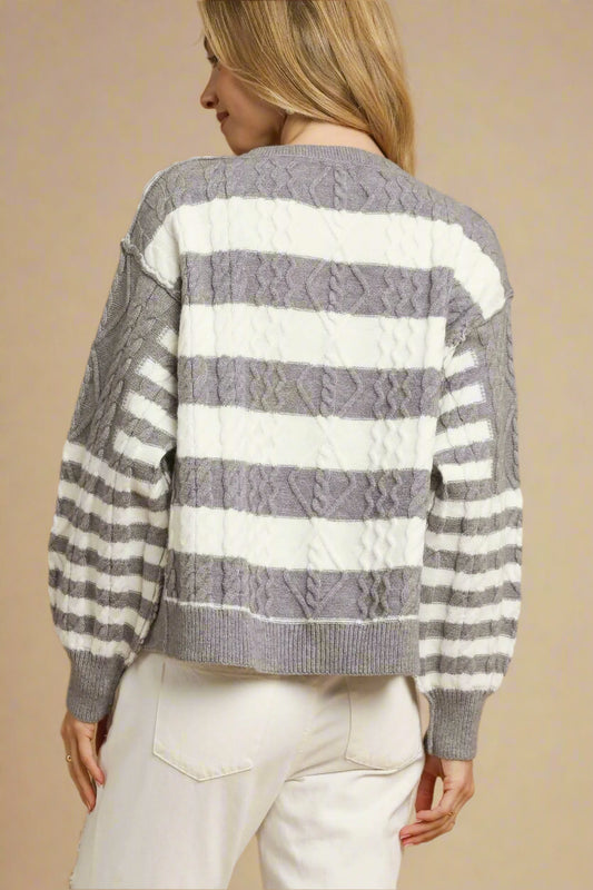 Woman wearing a gray and white striped sweater on a beige background