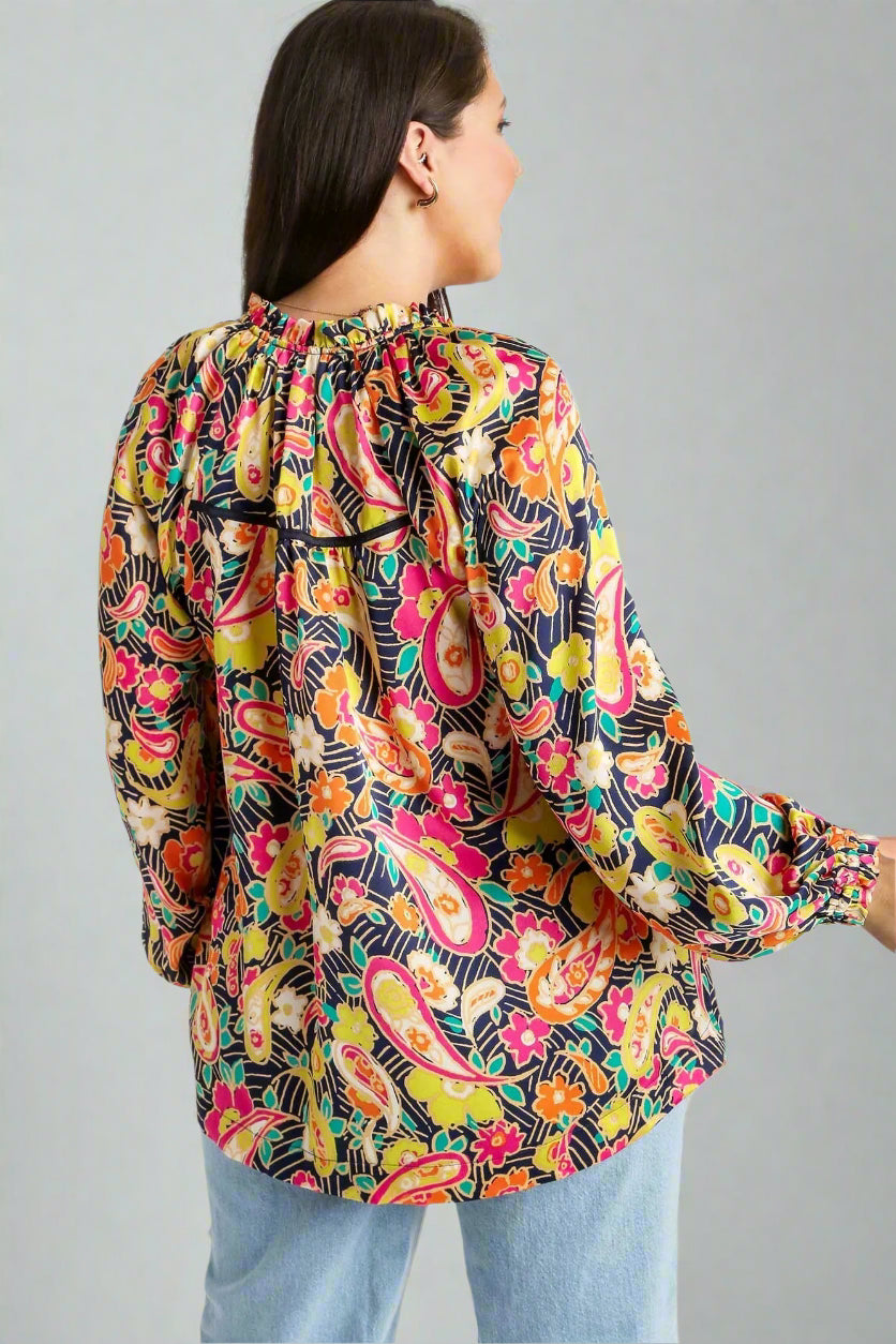 Woman wearing a colorful paisley patterned blouse