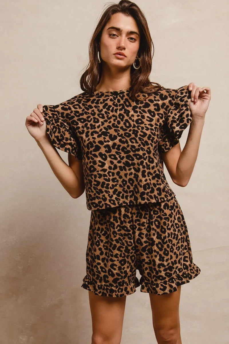 Woman wearing a leopard print outfit against a beige background