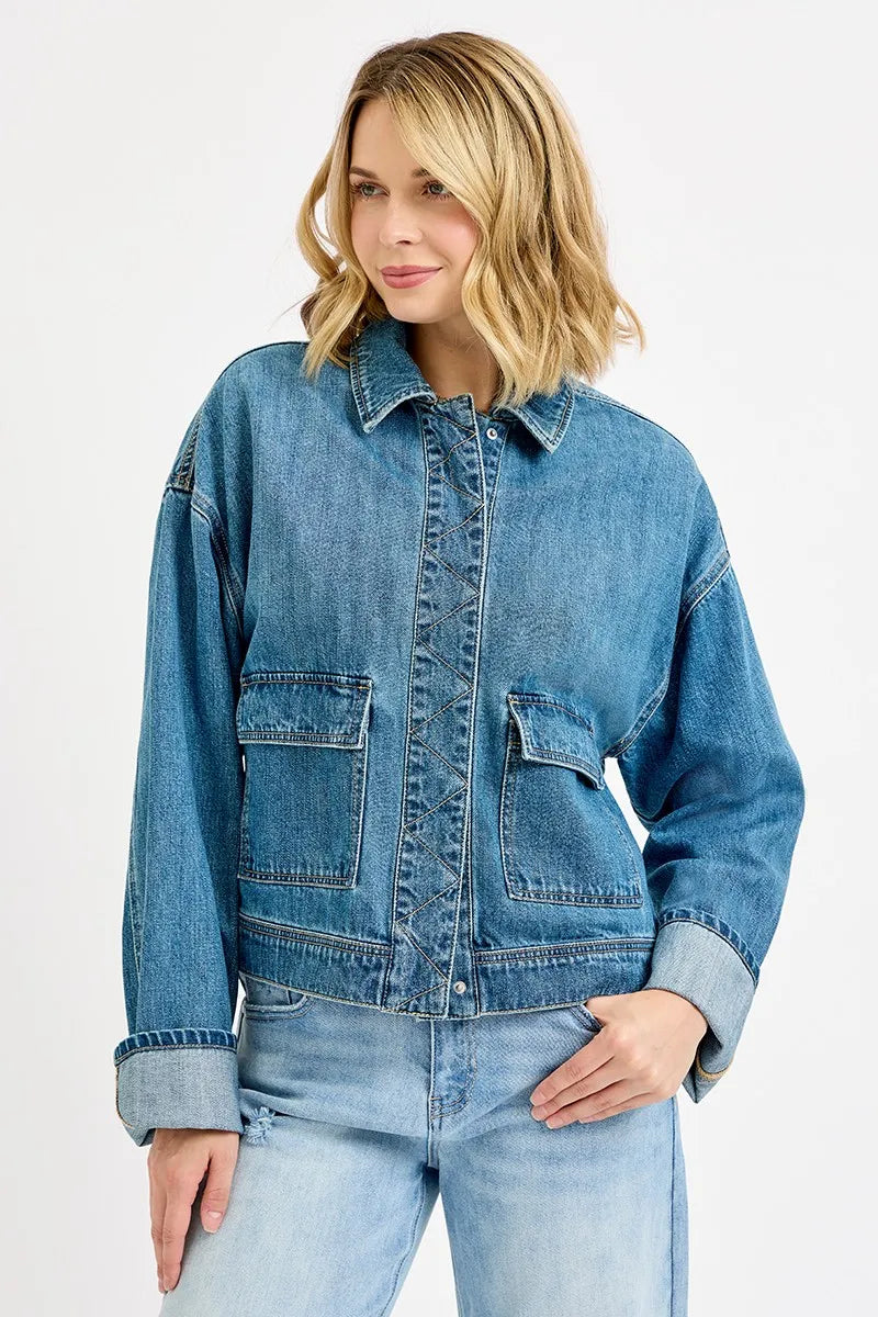 Woman wearing a blue denim jacket and jeans on a white background