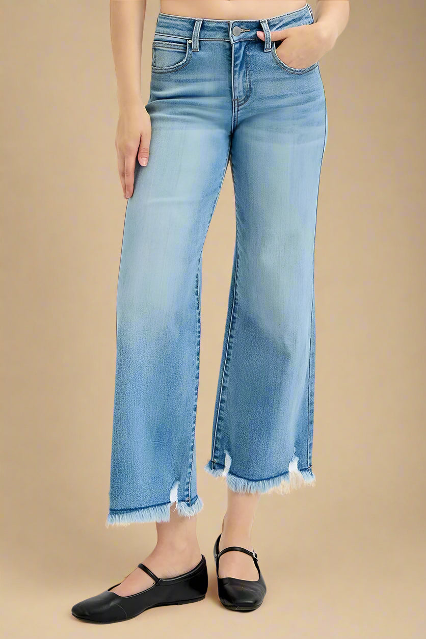 Person wearing light blue jeans with a white background