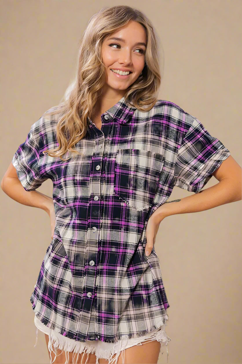 Woman wearing a plaid shirt with purple accents in a home setting