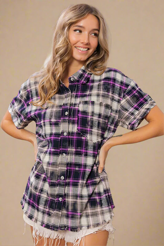 Woman wearing a plaid shirt with purple accents in a home setting
