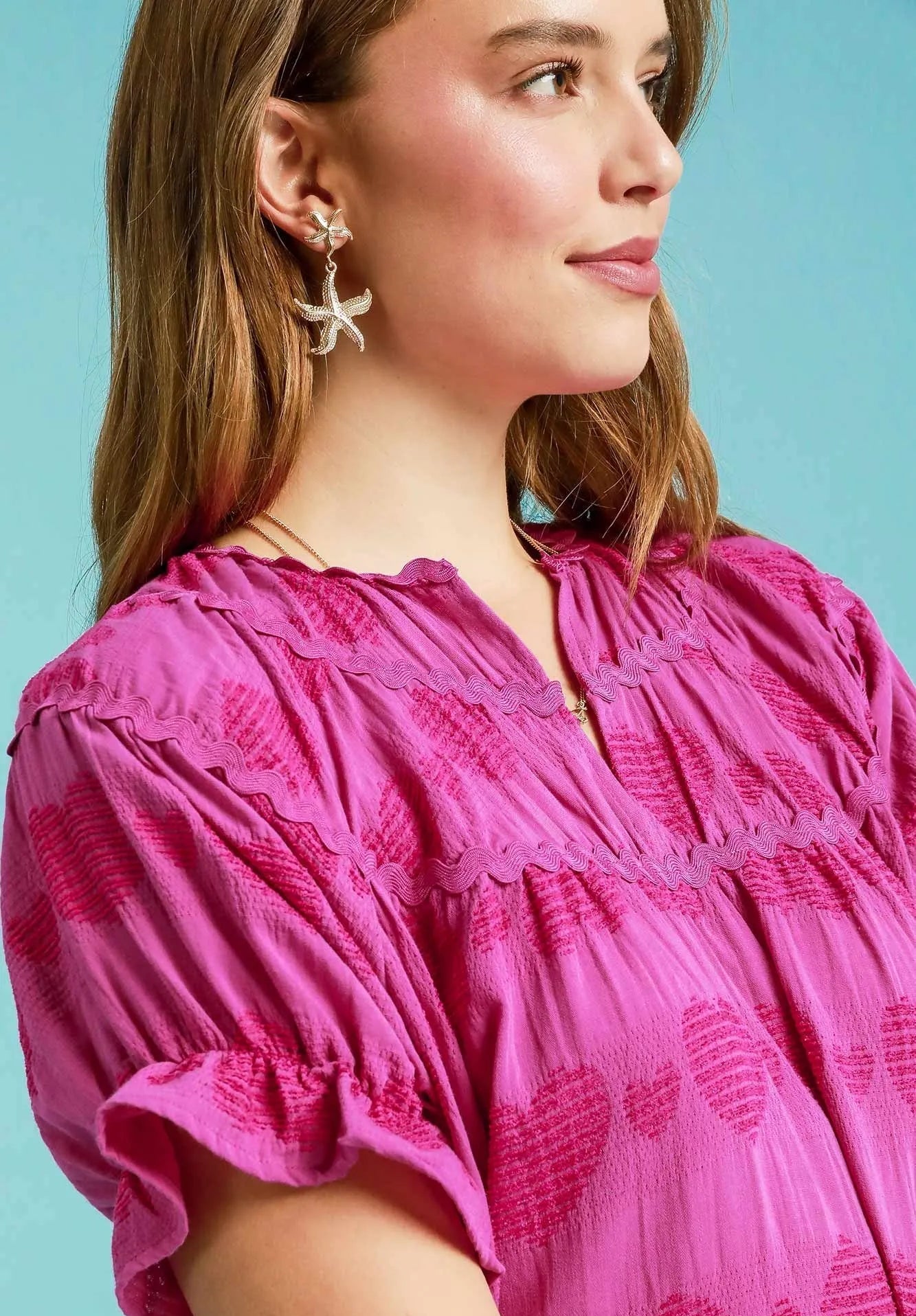 Woman wearing a pink dress with a light blue background