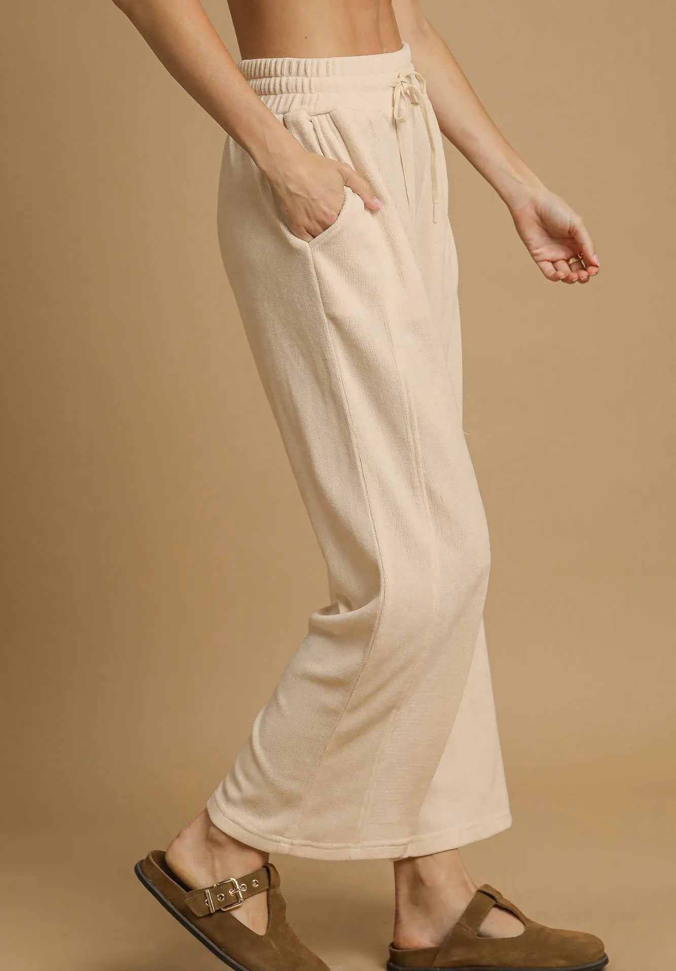 Beige pants worn by a person on a beige background