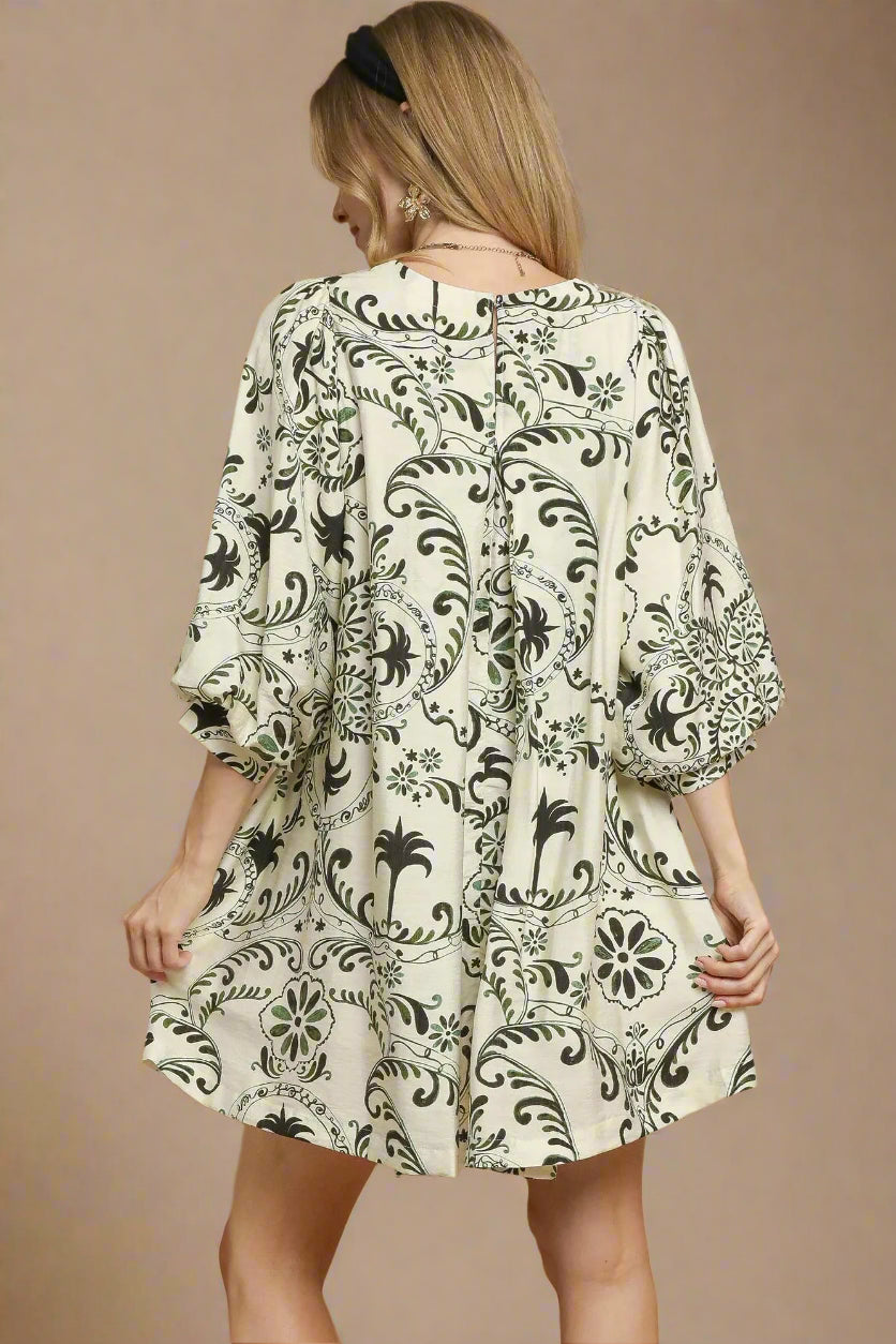 Woman wearing a patterned dress on a beige background