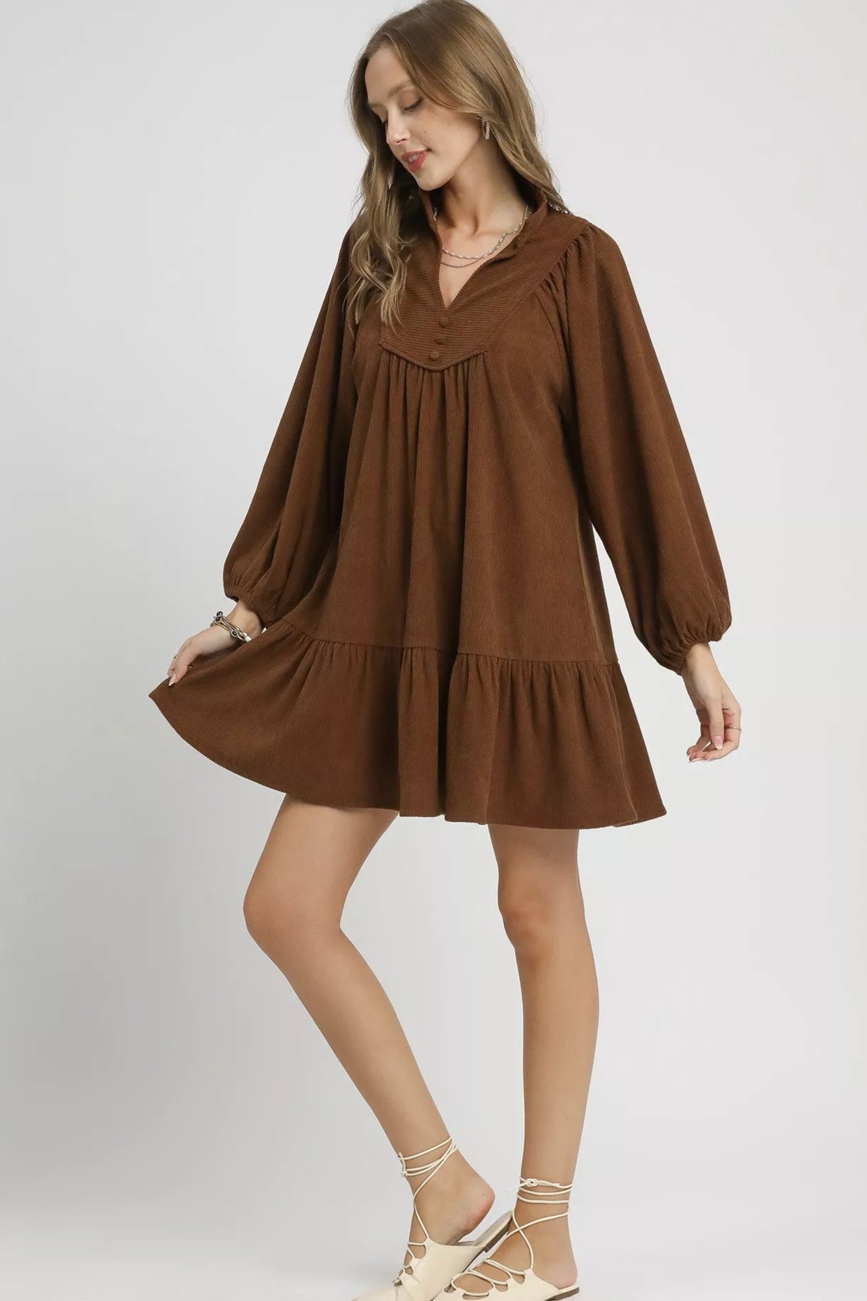 Woman wearing a brown dress on a white background