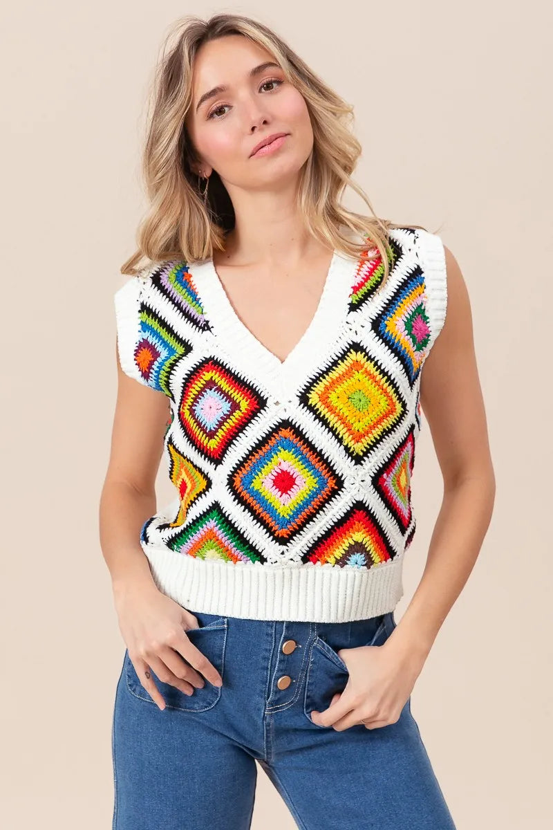 Woman wearing a colorful patterned sleeveless sweater against a beige background