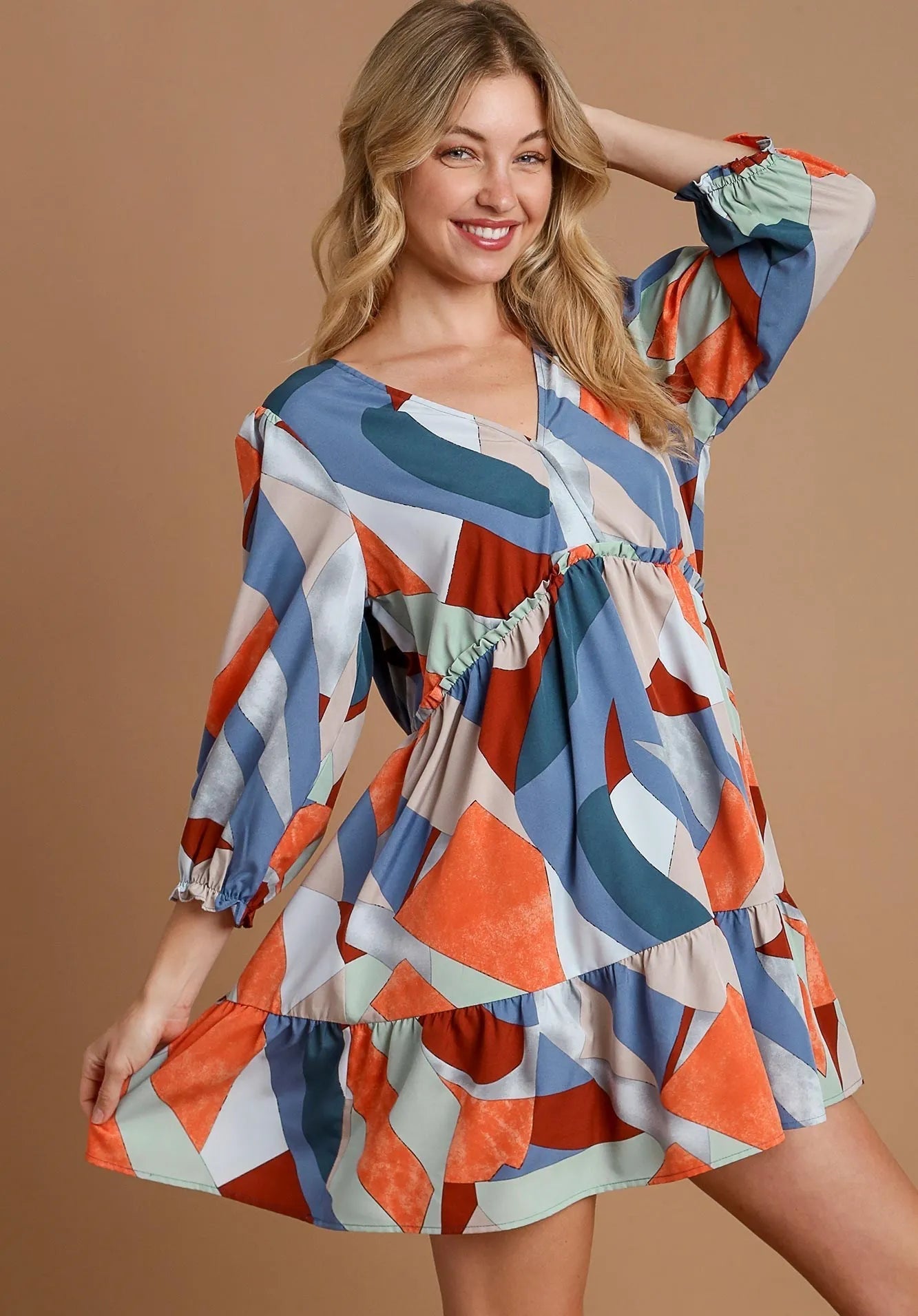 Woman wearing a colorful geometric patterned dress on a brown background