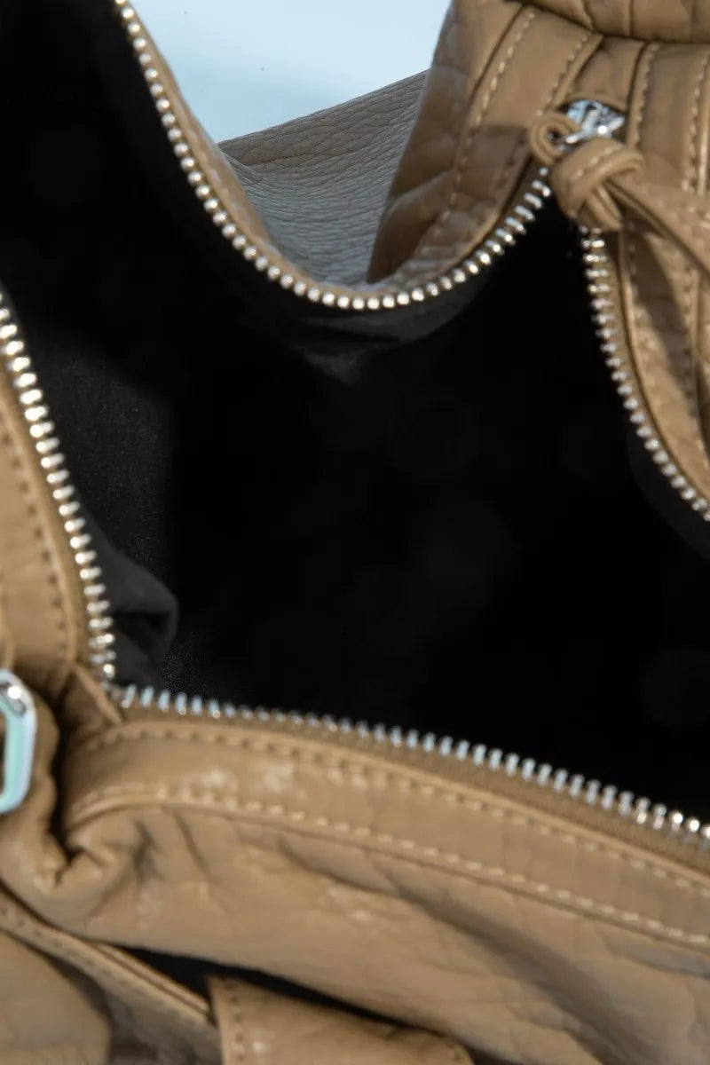 Close-up of a brown leather bag with a zipper