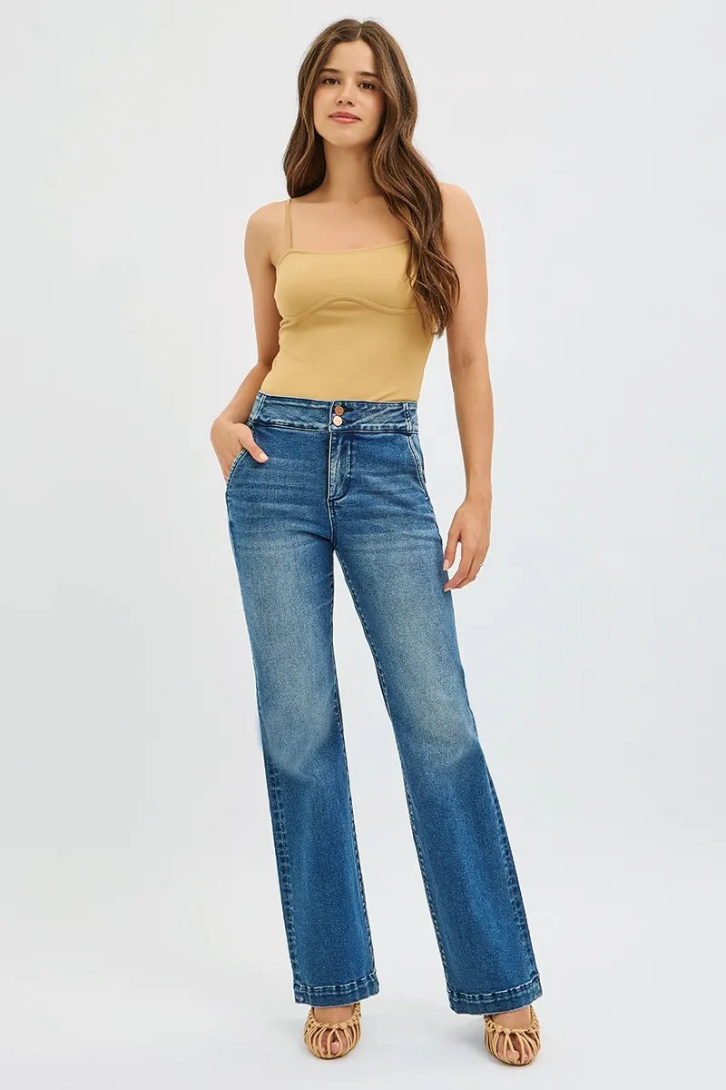 Woman wearing a yellow top and blue jeans on a white background