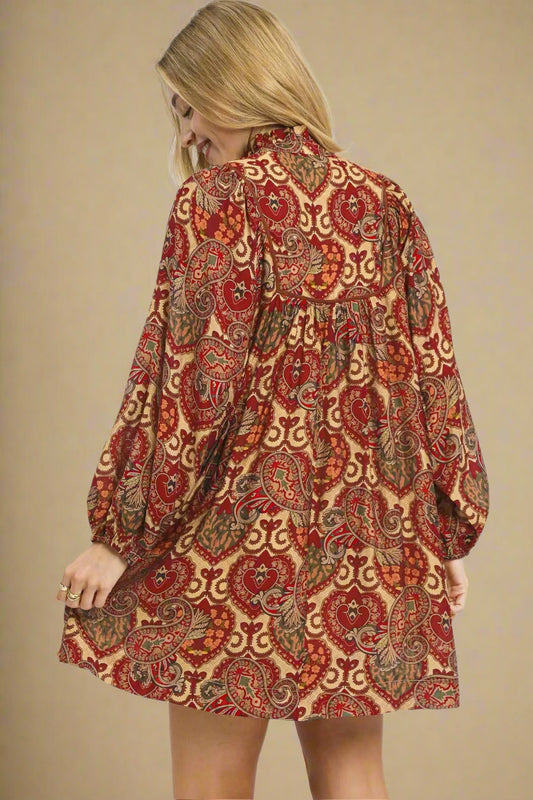 Woman wearing a red and gold patterned dress on a beige background