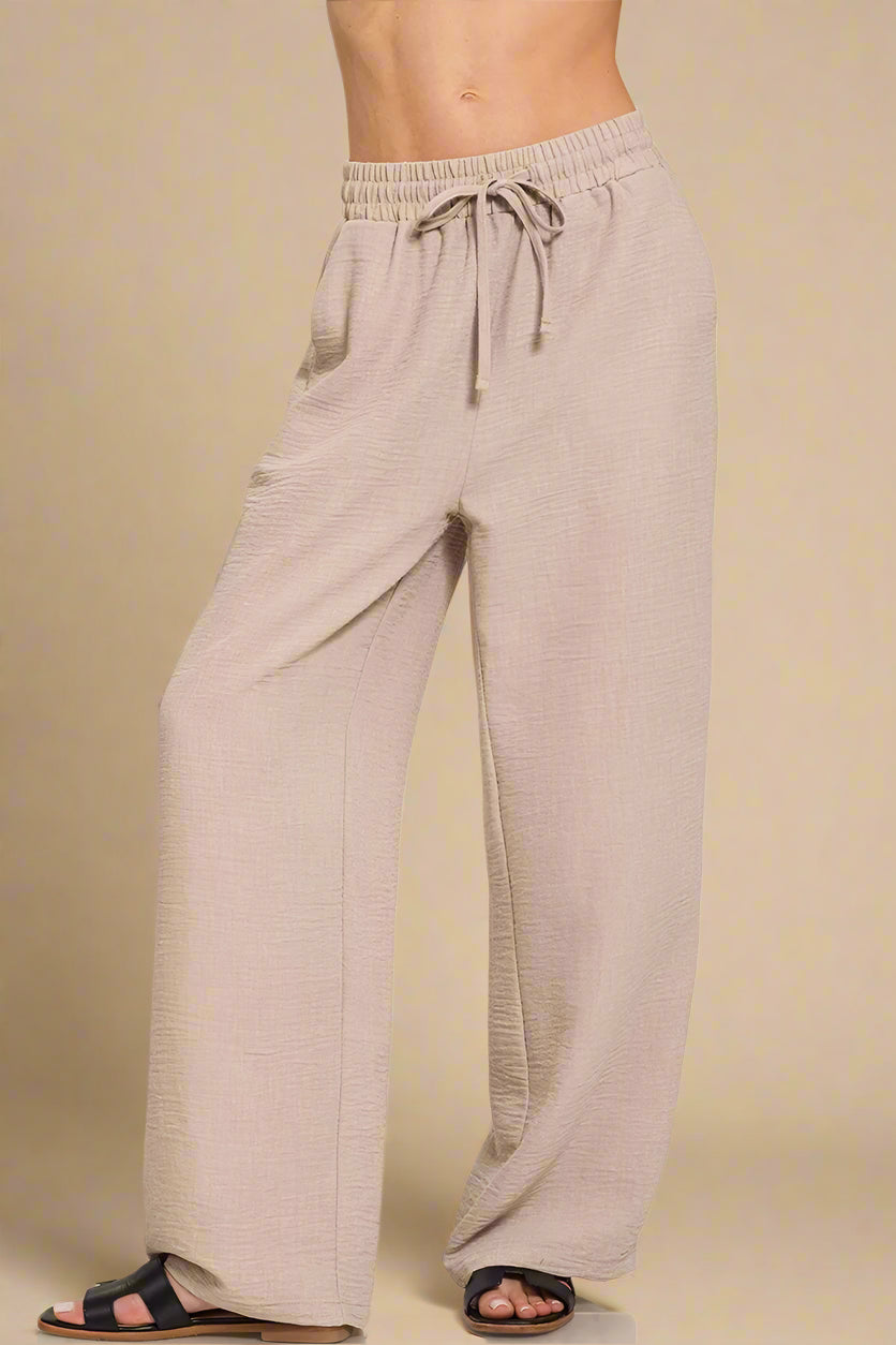Beige lounge pants with drawstring waist on a white background