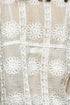 Close-up of beige fabric with white lace detailing