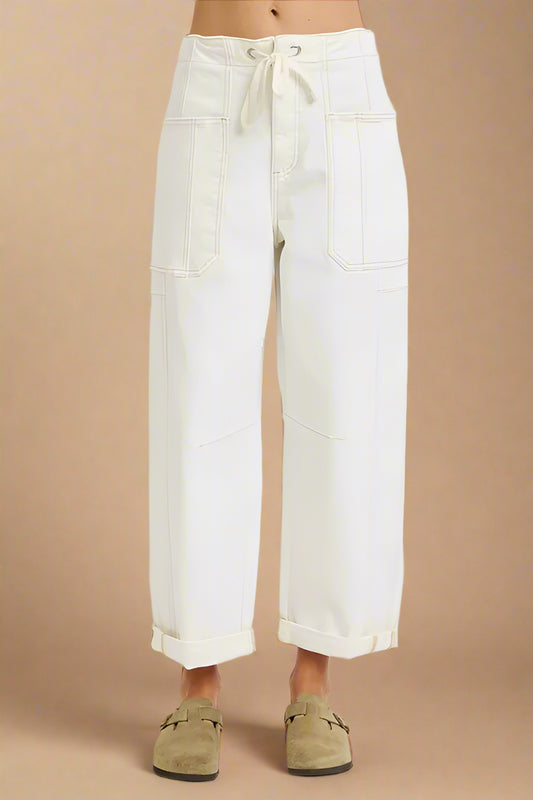 White wide-leg pants worn by a person on a beige background