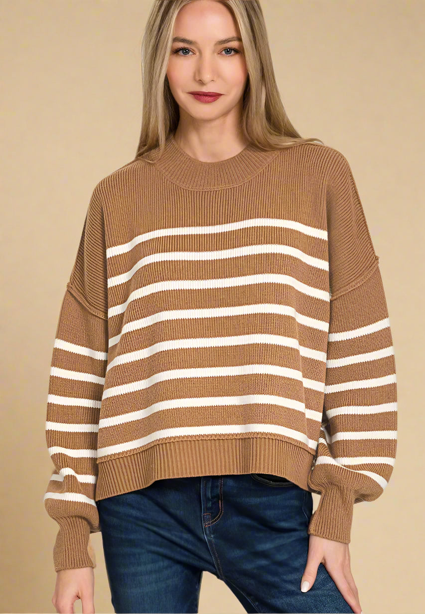 Woman wearing a brown and white striped sweater on a beige background