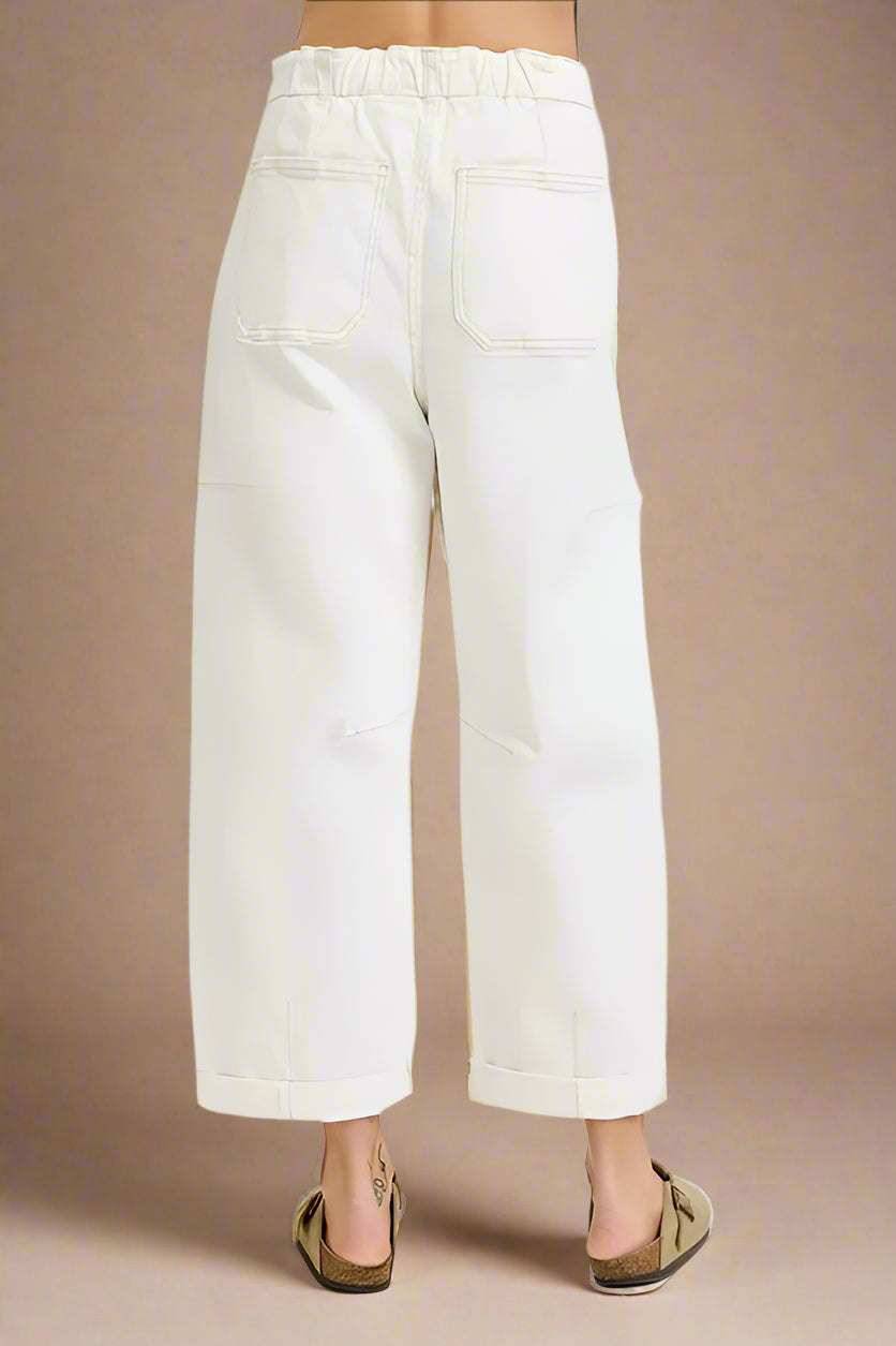 White pants worn by a person on a beige background