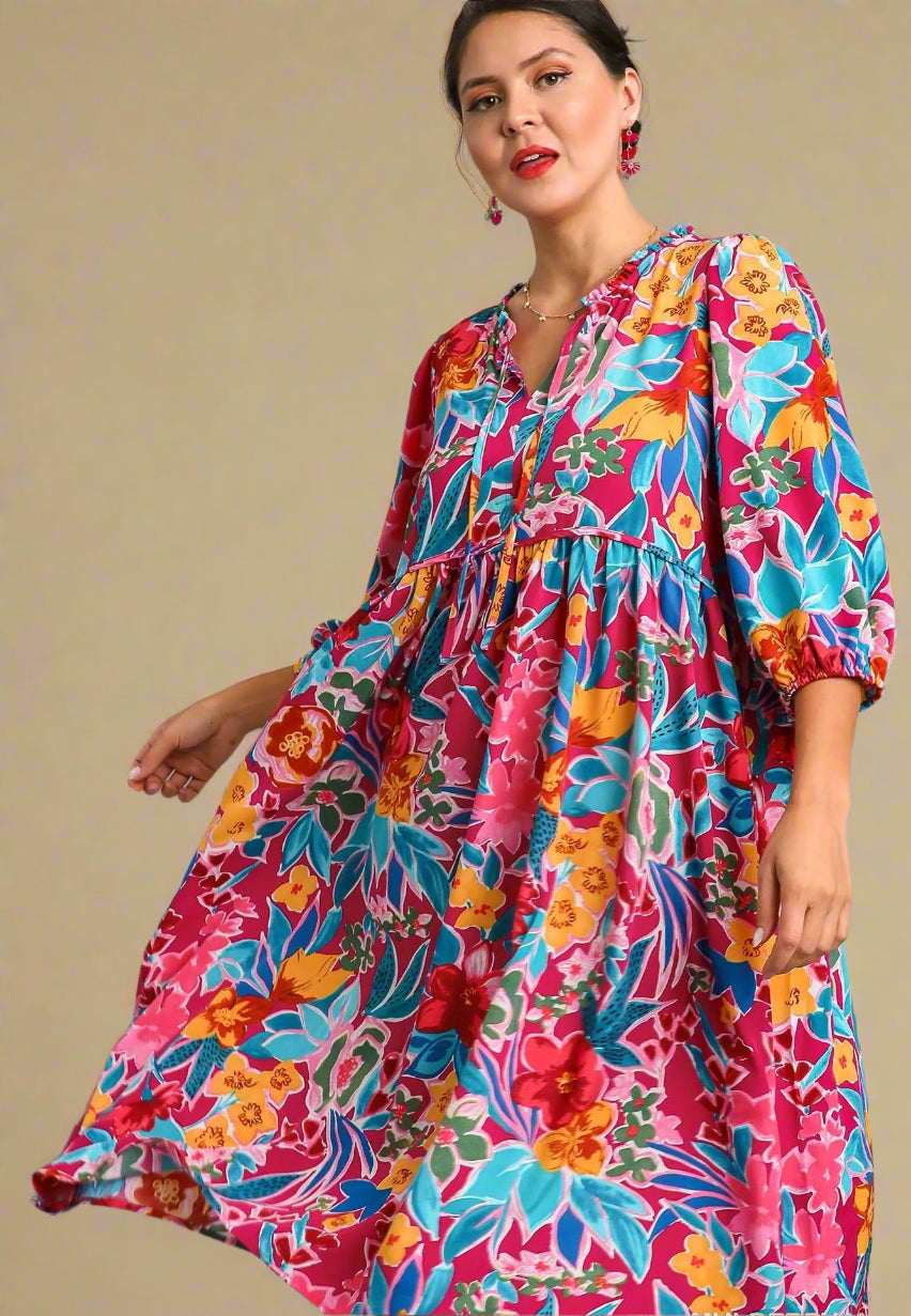 Woman wearing a colorful floral dress on a beige background