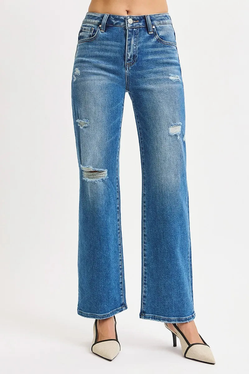 Blue jeans with distressed details on a white background