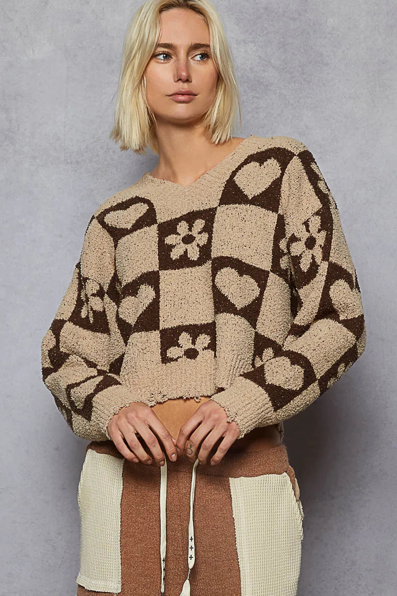 Woman wearing a patterned sweater against a gray background