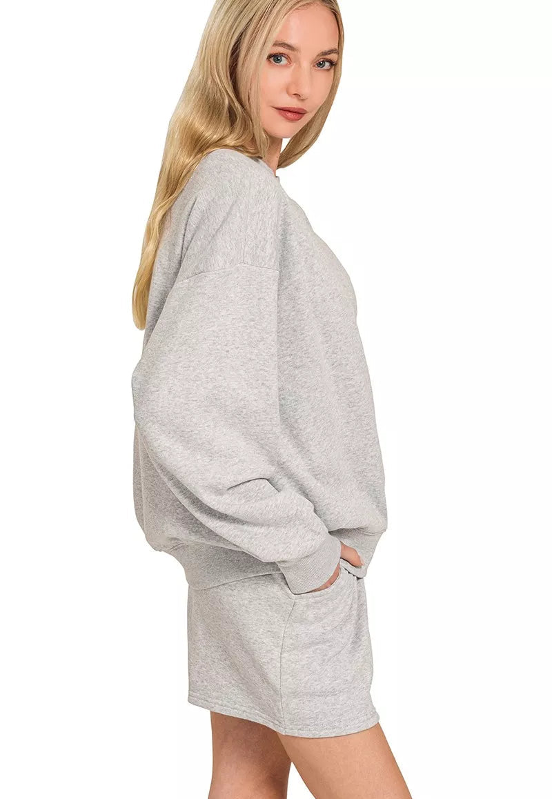 Woman wearing a gray sweatshirt dress on a white background